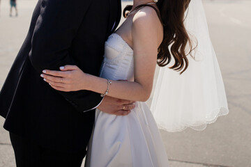 Poster - the groom and the bride in a wedding dress stand together on the street