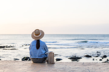 Sticker - Travel woman sit at the seaside under sunset time