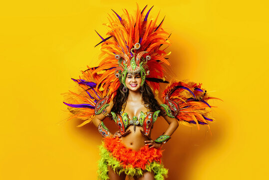 beautiful brazilian woman in brazilian carnival costume on yellow background