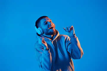 man with headphones in sweatshirt enjoying favorite music