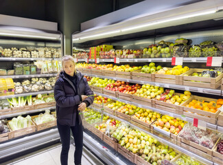 Wall Mural - Woman buying fruits and vegetables at the market