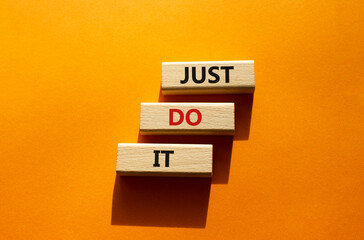 Wall Mural - Just do it symbol. Wooden blocks with words Just do it. Beautiful orange background. Business and Just do it concept. Copy space.
