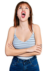 Canvas Print - Redhead young woman with arms crossed gesture angry and mad screaming frustrated and furious, shouting with anger looking up.