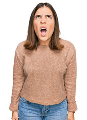 Sticker - Young beautiful woman wearing casual clothes angry and mad screaming frustrated and furious, shouting with anger. rage and aggressive concept.