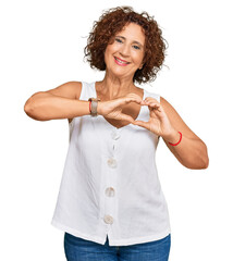 Poster - Beautiful middle age mature woman wearing casual white shirt smiling in love doing heart symbol shape with hands. romantic concept.