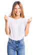 © Krakenimages.com - Beautiful caucasian woman with blonde hair wearing casual white tshirt excited for success with arms raised and eyes closed celebrating victory smiling. winner concept.