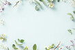 Leinwandbild Motiv Spring flower frame on blue background copy space flat lay mock up