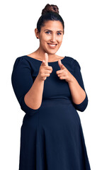 Poster - Young beautiful brunette woman wearing casual dress pointing fingers to camera with happy and funny face. good energy and vibes.