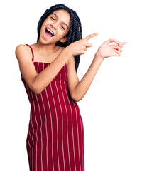 Poster - Cute african american girl wearing casual clothes smiling and looking at the camera pointing with two hands and fingers to the side.