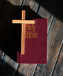 wooden cross and bible on wooden background