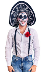 Poster - Man wearing day of the dead costume over background sticking tongue out happy with funny expression. emotion concept.