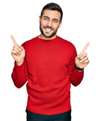 Wall Mural - Young hispanic man wearing casual clothes smiling confident pointing with fingers to different directions. copy space for advertisement