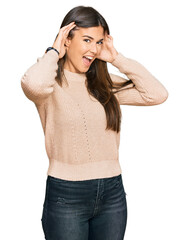 Poster - Young brunette woman wearing casual winter sweater smiling cheerful playing peek a boo with hands showing face. surprised and exited