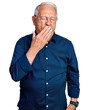 © Krakenimages.com - Senior man with grey hair wearing casual shirt and glasses bored yawning tired covering mouth with hand. restless and sleepiness.