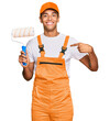 © Krakenimages.com - Young handsome african american man wearing cap and painter clothes holding painting roll pointing finger to one self smiling happy and proud