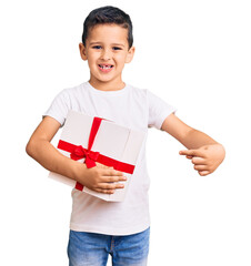 Wall Mural - Little cute boy kid holding gift smiling happy pointing with hand and finger