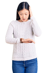 Sticker - Young beautiful chinese woman wearing casual sweater looking at the watch time worried, afraid of getting late