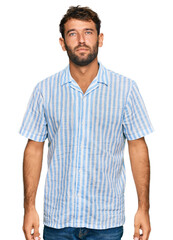 Poster - Handsome young man with beard wearing casual fresh shirt relaxed with serious expression on face. simple and natural looking at the camera.