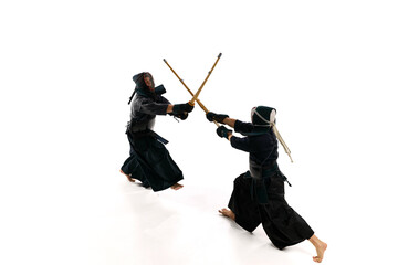 Wall Mural - Top view. Dynamic image of two men, professional kendo athletes in uniform training with shinai sword against white studio background. Concept of martial arts, sport, Japanese culture, action, motion