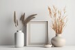 © The 2R Artificiality - frame mockup on gray table, modern beige ceramic vases with dry grass.Neutral color. White wall background. Scandinavian interior. Copy space. Generative AI
