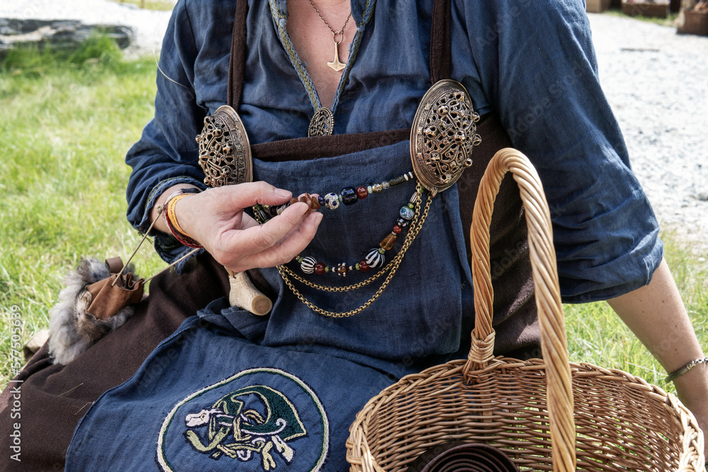 Photo Stock Woman in traditional Norse costume with Viking Turtle Brooches  and glass beads. Clothes worn by a Viking woman, apron, jewelry, old Norse  dress. A Reconstructed Viking Women richly embroidered Outfit. |