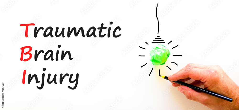 TBI traumatic brain injury symbol. Concept words TBI traumatic brain injury on paper on a beautiful white background. Green light bulb icon. Medical and TBI traumatic brain injury concept. Copy space.
