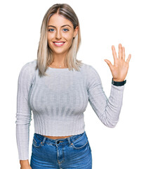 Wall Mural - Beautiful blonde woman wearing casual clothes showing and pointing up with fingers number five while smiling confident and happy.