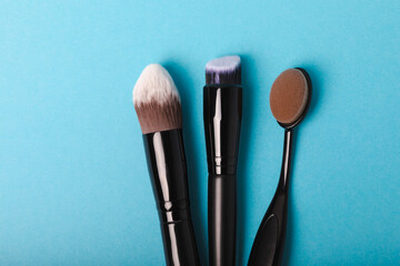 Wall Mural - Set of cosmetic brushes on a blue background. Makeup brushes. Makeup tool. Beauty concept.Professional brushes for applying cosmetics eyeshadows, make-up powder. Place for text. Copy space. Flat lay.