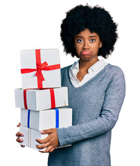 Poster - Young african american woman holding gifts depressed and worry for distress, crying angry and afraid. sad expression.