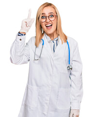 Wall Mural - Beautiful caucasian woman wearing doctor uniform and stethoscope pointing finger up with successful idea. exited and happy. number one.