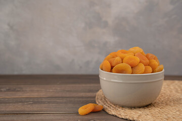 Wall Mural - Bowl of dried apricots on the old wooden stand, selective focus.