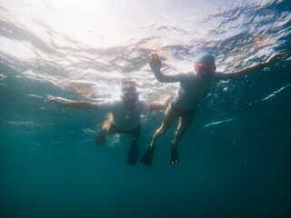  couple snorkeling in clear tropical sea