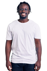 Wall Mural - Young african american man with braids wearing casual white tshirt with a happy and cool smile on face. lucky person.