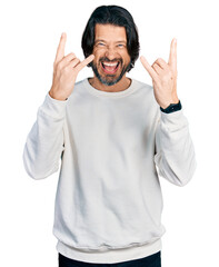 Poster - Middle age caucasian man wearing casual clothes shouting with crazy expression doing rock symbol with hands up. music star. heavy music concept.