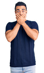 Canvas Print - Young hispanic man wearing casual clothes shocked covering mouth with hands for mistake. secret concept.