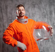 Retro futuristic astronaut in a spacesuit with a bright orange jumpsuit and a spherical glass helmet