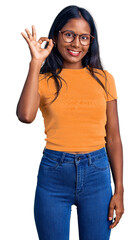 Wall Mural - Young indian girl wearing casual clothes and glasses smiling positive doing ok sign with hand and fingers. successful expression.