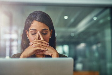 Fototapete - Feeling drained from all her efforts. Shot of a young businesswoman looking stressed out while working in an office.
