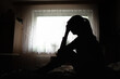 © kieferpix - silhouette of a woman sitting on bed feeling sleepless, suffering from emotional stress