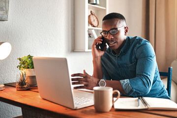 Poster - I always network. Cropped shot of a handsome young businessman sitting alone in his home office and talking on his cellphone.