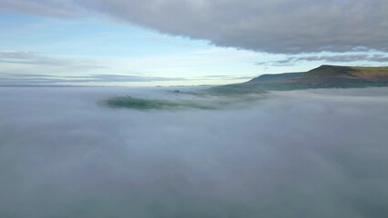 Wall Mural - Aerial view flying sideways over a bank of fog in a rural area (Llangorse Lake, Brecon Beacons)