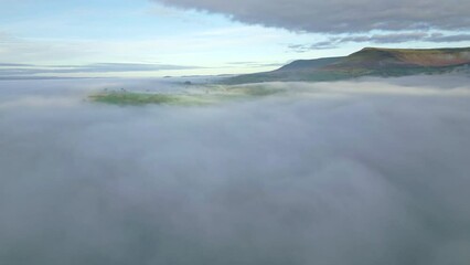 Wall Mural - Aerial view of hills emerging above low cloud and fog in a rural farming area