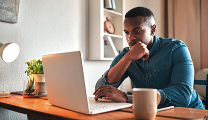 Poster - Is this really the best business move. Cropped shot of a handsome young businessman sitting in his home office and looking contemplative while working on his laptop.