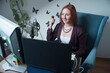 uśmiechnięta kobieta siedząca przed ekranami komputerów, podczas pracy