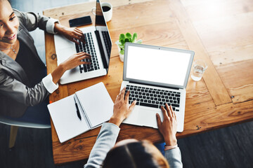 Aufkleber - Business has been booming since we shifted online. High angle shot of two businesswomen working on laptops in an office.