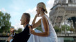 © Media Whale Stock - Chatting young couple on vacation. Action. A beautiful elegant girl in a white dress sits with her man and communicates against the background of sights in the summer.