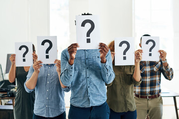 Fototapete - Who How What Where When Why. Shot of a group of businesspeople holding questions marks in front of their faces.