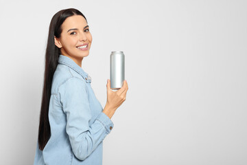 Sticker - Beautiful happy woman holding beverage can on light grey background. Space for text