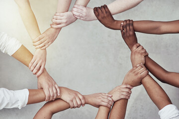 Poster - We are more powerful together. Shot of a group of hands holding on to each other.