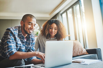 Aufkleber - Managing money matters with wireless technology. Shot of a young couple using a laptop while working on their home finances.